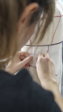 Moda tasarımcıları dikkatlice kıyafet yapar.