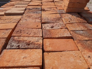 Yapı malzemesi olarak kullanılmaya hazır düzgünce dizilmiş tuğlaların yakın plan portresi
