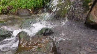 Küçük nehir suyu, kayalar ve dökülen su.