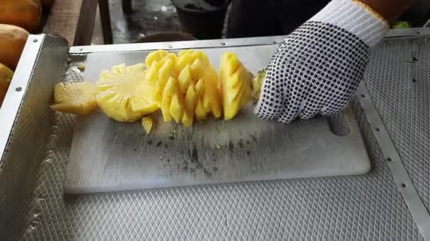 パイナップルは切断板の小さな部分に切断されています — ストック動画