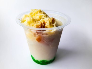 Durian Cendol Buzlu İçeceği. Üstünde rendelenmiş peynir ve ekmek dilimleri var.