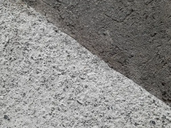 Kalıplaşmış beton yüzeyin yakın plan çekimi iki farklı çimento tonu arasındaki zıtlığı gözler önüne seriyor. Geçmişler, dokular veya inşaatla ilgili konular için ideal.