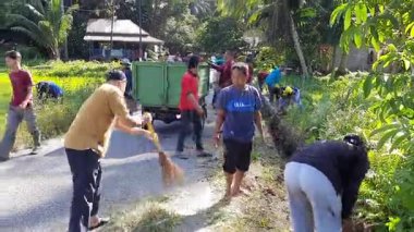 Pariaman, Endonezya - 26 Şubat 2025: Kuzey Pariaman İlçesindeki köy temizlik işçileri Ampalu Köyü 'ndeki yol kenarı ve drenaj kanallarını temizlemek için birlikte çalışıyorlar