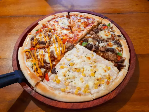Tahta bir tabakta farklı malzemelerle çeşitli pizza dilimleri, ahşap bir masanın üzerine yerleştirilmiş. Fast Food restoranı, menü tasarımları ve reklamcılık için mükemmel.
