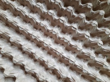 Bıldırcın yumurtalarını tutmak için kullanılan geri dönüşümlü kağıt tepside köşegen bir desen yakın plan. Soyut geometrik dizaynlı desenli yumurta karton yüzeyi