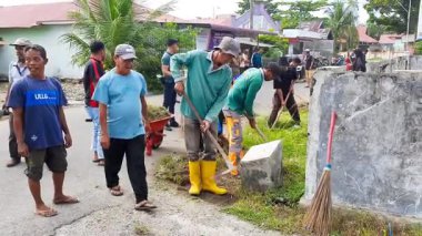 Pariaman, Endonezya - 28 Mayıs 2025: Geleneksel araçlarla Naras Hilir 'deki bir toplum temizliği sırasında köy temizlik işçileri yol kenarındaki aşırı büyümeyi temizledi