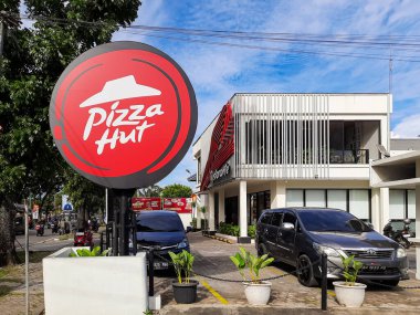 Padang, Endonezya - 1 Haziran 2025: Kırmızı yuvarlak tabelalı Pizza Hut restoranının dış görünümü. Pizza ve günlük yemeklerle bilinen uluslararası fast food zinciri.