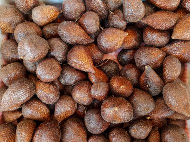 Endonezya 'da geleneksel bir meyve dükkanında satılan pullu kahverengi derili, taze Salak Pondoh meyvelerinin üst görüntüsü. Besin ve lezzet açısından zengin tropikal yılan meyvesi