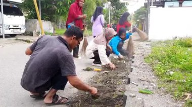Pariaman, Endonezya - Agu 13, 2025: Köy temizliği işçileri, Naras I 'deki bir toplum temizliği sırasında yol kenarındaki aşırı büyümeyi temizliyor.