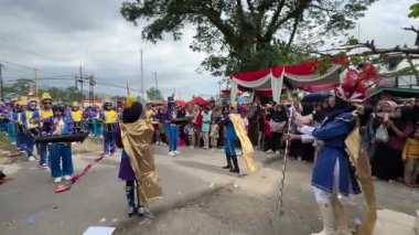 Padang Pariaman, Endonezya - 17 Ağustos 2025: Endonezya Bağımsızlık Günü geçit töreninde bando gösterisi. Mavi kostümler. Liderleri baton çevirme hareketleri olan bir kadın bando şefi..