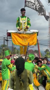 Padang Pariaman, Endonezya - 17 Ağustos 2025: Endonezya Bağımsızlık Günü kutlamaları için düzenlenen yürüyüş bandosu gösterisinde öğrenciler davul dublörlüğü yapıyor.
