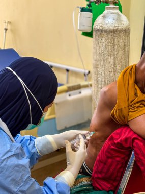 Pulmonolog plevral ponksiyon yapıyor. Tedavi sırasında hasta kaburgalarının yakınına sıvı yerleştirilmeden önce anestezi yapıyor. Tanınmayan insanlar