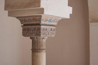 Ornate column with blue painted details in a courtyard at Nasrid Palace, Alcazaba, Spain