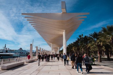 Malaga, Spain - January 15, 2023: People walking under the Pergolas de la Victoria (spanish for Pergolas of Victoria)  built in contemporary style at the pier