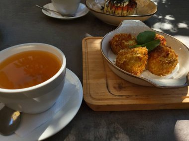 Sıcak çay ve bir porsiyon gevrek kahvaltı ahşap tepside sunuluyor..