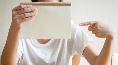Evindeki boş defterleri gösteren Asyalı bir kadının görüntüsünü kapat..