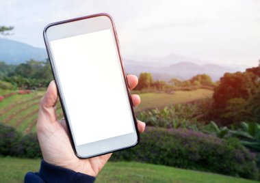 Young Woman using mobile smart phone white blank screen on national park viewpoint background in Northern Thailand. image for mockup.