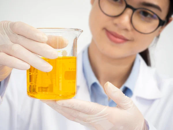 Sıvı çözeltiyi analiz eden kimyager kadın elinde tıbbi cam şişeyle hastalık DNA uzmanlığı sonuçlarını araştırıyor. Bilim adamı doktor hastane laboratuvarında biyokimya tanısı geliştiriyor.