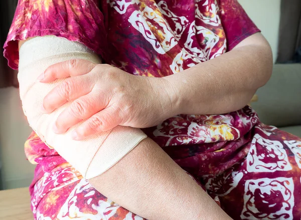 Elbow pain. Woman hold elbow because pain. Broken elbow and forearm with bandage. forearm wrapped in bandage. Retainer for recovery and release pain at joint. Orthopedic.