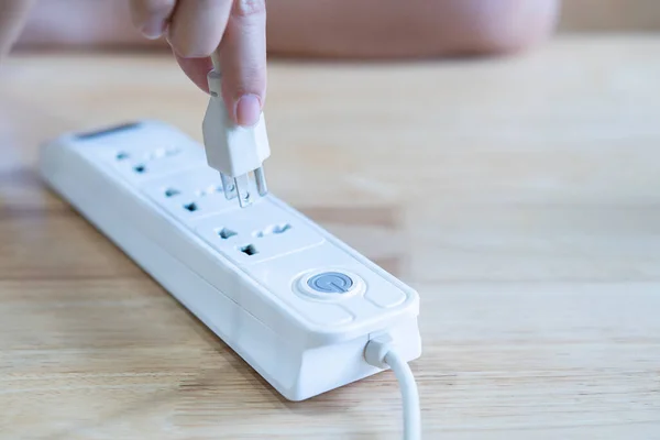 Elektrik prizine fiş takan bir kadının yakın çekimi. Elektrikçinin profesyonel ekipmanı