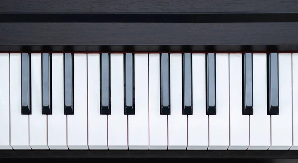 Black and white piano keys, taken from above. Piano keyboard. Flat top view. Horizontal photo