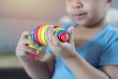 Sevimli küçük çocuk evde renkli oyuncaklarla oynuyor. Genç çocuklar için evrim ve paleontoloji oyunu. Çocuklar öğrenme konsepti.