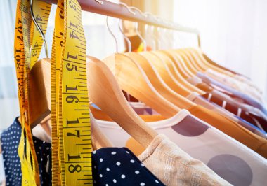 Terzi dükkanında moda tasarımı geçmişi olan asma ve ölçme bandında birçok kıyafet var. giyim, tasarım, moda, terzi konsepti. 