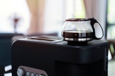 Mutfak masasında küçük ev aletleriyle güzel bir sabah. Kahve makinesinde sıcak kahve hazırlıyorum.