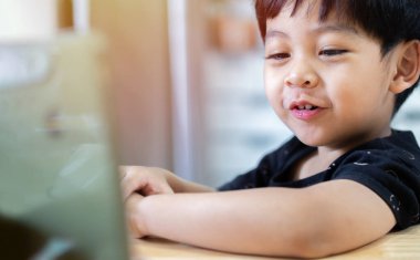 Mutlu küçük şirin Asyalı oturma, rahatlama ve cep telefonuyla eğlenme ya da oyun oynama, evde komik sosyal medya videoları izleme. 