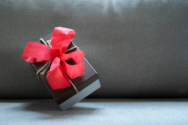 Een Geschenk Verpakt Donkergrijs Papier Met Luxe Rood Lint Lichtgrijze — Stockfoto