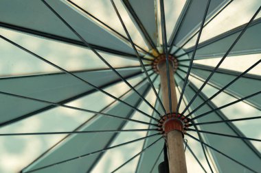 İki ton mavi renkli arka plan. Gökyüzünde uçan renkli şemsiyeler. Caddenin üzerinde mavi gökyüzü arkaplanlı renkli şemsiye ile dekorasyon.