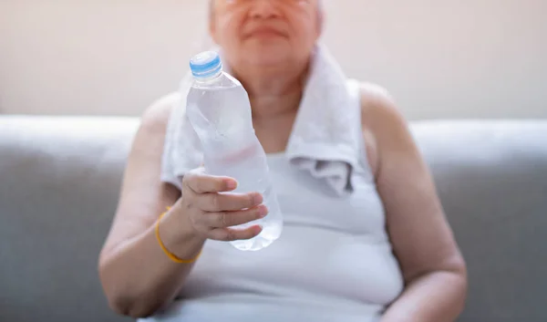 Elderly Woman Sitting Sofa Exhausted Daily Training Holding Bottle Water — Stock Photo, Image
