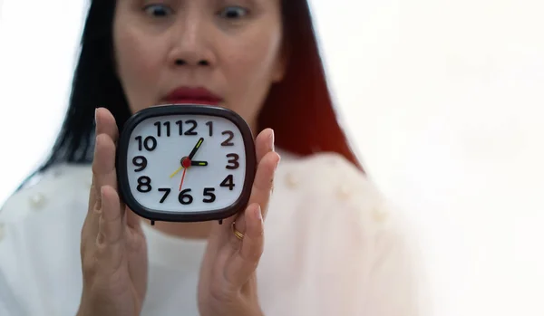 被迷人的亚洲女人射中震惊惊讶地盯着相机盖住了被白色背景隔离的时钟 钟表的选择性聚焦 — 图库照片