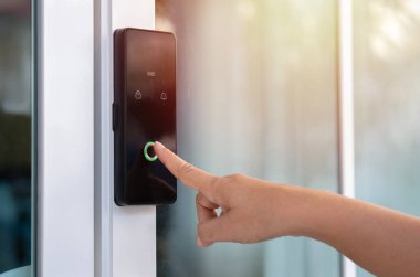 Bir kadının parmağını, odanın önündeki dijital dokunmatik tuş takımının kapı kilidine şifre girerken yaklaş. Kişisel kayıt, Airbnb, Modern güvenlik, Anahtarsız, Geçici kodlar.