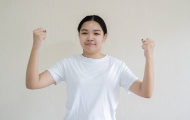 Neşeli, çekici Asyalı kız yumruk tokuşturma ve sevinçle gülümseme, kazanma. Mutlu ol konsept.