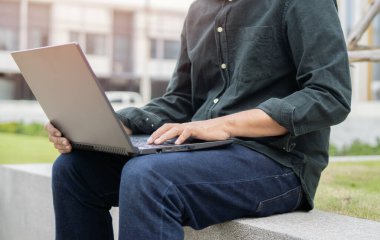 Uzaktan kumandayla çalışan kurumsal bir adamın kesilmiş görüntüsü, dizüstü bilgisayarla oturuyor, online video konferansına katılıyor..