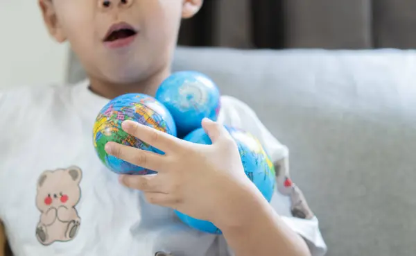 Earth day. World environment day. Asian kid hands holding earth globes. CSR. Big data research, Discovery, Planet, go green