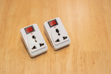 Tahta masadaki beyaz plastik prizleri kapatın. Elektrik konsepti. Boşluğu kopyala.