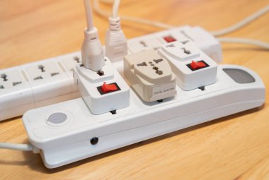 Evdeki ahşap zeminde kesilmiş uzatma kablosu görüntüsü. Elektrikçi ekipmanı konsepti. Seçici odak.