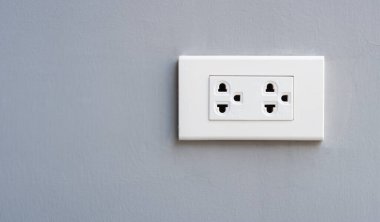 Evin içindeki beton bir duvarda beyaz elektrik prizine yakın plan. Boşluğu kopyala.