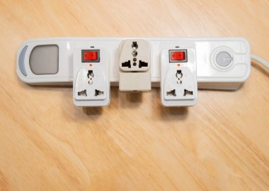 Ahşap zemin üzerinde maltiple elektrik prizine birçok şarj portu boşalt. Elektrik tüketimi kavramı.