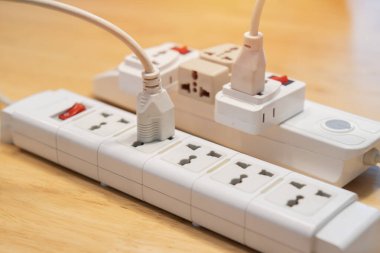 Birçok elektrik fişleri ahşap masa üzerinde bir güç beyaz şerit veya uzatma bloğu bağlı. Yüksek teknoloji akıllı şerit
