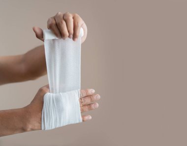 El bandajları açık bej arka planda. Beyaz tıbbi pamuklu sargı bezi konsepti.