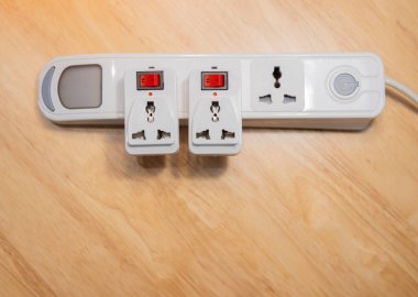 Tahta arka planda farklı adaptörleri olan elektrik uzatma kablosu. Üst Manzara. Boşluğu kopyala