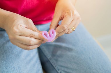 Adet bardağı C 'nin nasıl kullanılacağını, elinde regl bardağı, kristal günler için modern yöntemler. Jinekoloji ve hijyen ürünleri konsepti.