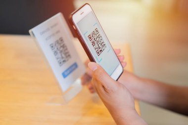 QR kod ödemesi ve nakit teknolojisi konsepti. Erkeklerin el taramasının yan görünümü Strore 'da dijital ödeme için QR Kodu.