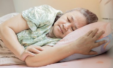 Uykusuzluk çeken endişeli yaşlı kadın. Yatakta gözleri açık yatan yaşlı kadın. Yetişkin bir kadın evde uyuyamaz..