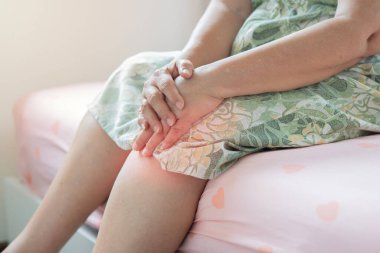 Yaşlılık, sağlık sorunları ve insanların konsepti - yaşlı kadın sabah kalktığında bacağında ağrıdan muzdarip