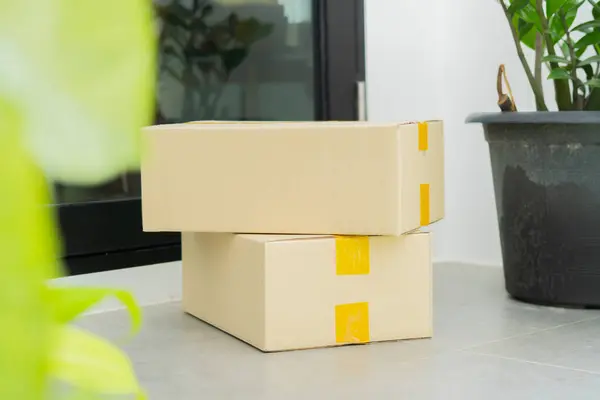 Kapıya yakın karton kutular. Paket teslimat servisi. Evin girişine yakın bir yerde teslim edilmiş. Seçici odak.