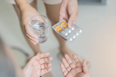 Bakıcının huzurevindeki yaşlı kadına ilaç ve bir bardak su verişi. Ev sağlığı konsepti.